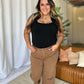 Woman wearing RFM full size high rise garment dye wide leg jeans in a relaxed setting.