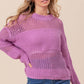 Woman wearing BiBi Openwork Long Sleeve Knit Top in purple, styled casually with blue jeans.