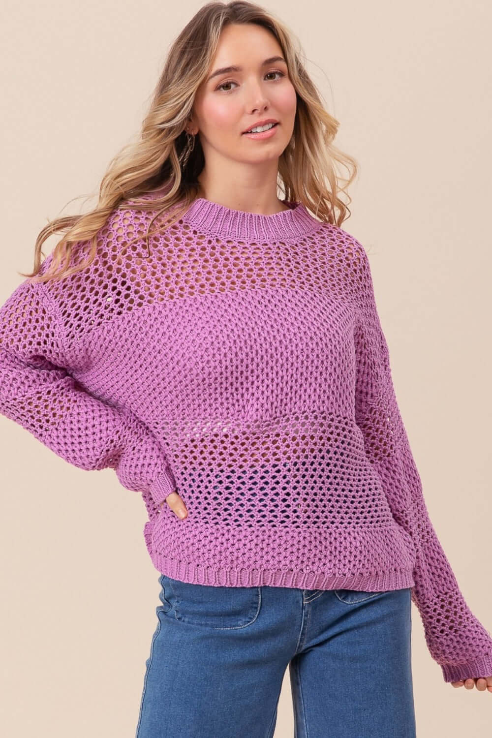 Woman wearing BiBi Openwork Long Sleeve Knit Top in purple, styled casually with blue jeans.