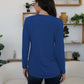 Woman wearing blue FAM-FAM round neck long sleeve t-shirt in stylish home setting