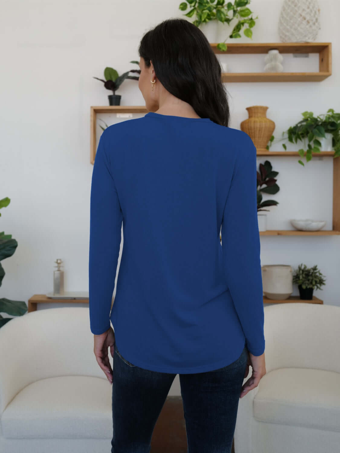 Woman wearing blue FAM-FAM round neck long sleeve t-shirt in stylish home setting