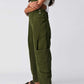 Woman wearing army green Bella Road pocketed wide strap denim overalls, side profile. Fashionable and functional outfit choice.