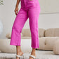 Woman modeling RFM Jeans Crop Chloe Full Size Tummy Control High Waist Raw Hem Jeans in vibrant pink.