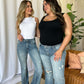 Two women wearing Judy Blue medium rise tummy control destroy flare jeans, showcasing the stylish fit and distressed detailing.