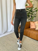 Woman wearing RFM Full Size High Rise Tummy Control Skinny Jeans in black with white sneakers.