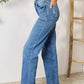 Woman wearing Judy Blue High Waist Distressed Jeans, full-size, side view showcasing classic fit and contemporary style with high waist design.