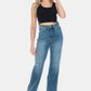 Woman wearing Judy Blue full size tummy control jeans with raw hem and high-waist design paired with black top.