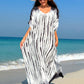 Woman in slit tie-dye half sleeve cover up on the beach, wearing a white hat and sunglasses, with ocean background.