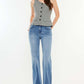 Woman modelling Ultra High Rise Cat's Whiskers Jeans with vintage detailing and a grey buttoned top, showcasing a chic high-waisted silhouette.