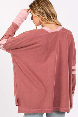 Woman wearing Mineral Wash Side Slit Contrast T-Shirt in pink with long sleeves and keyhole details, showing back view of trendy top