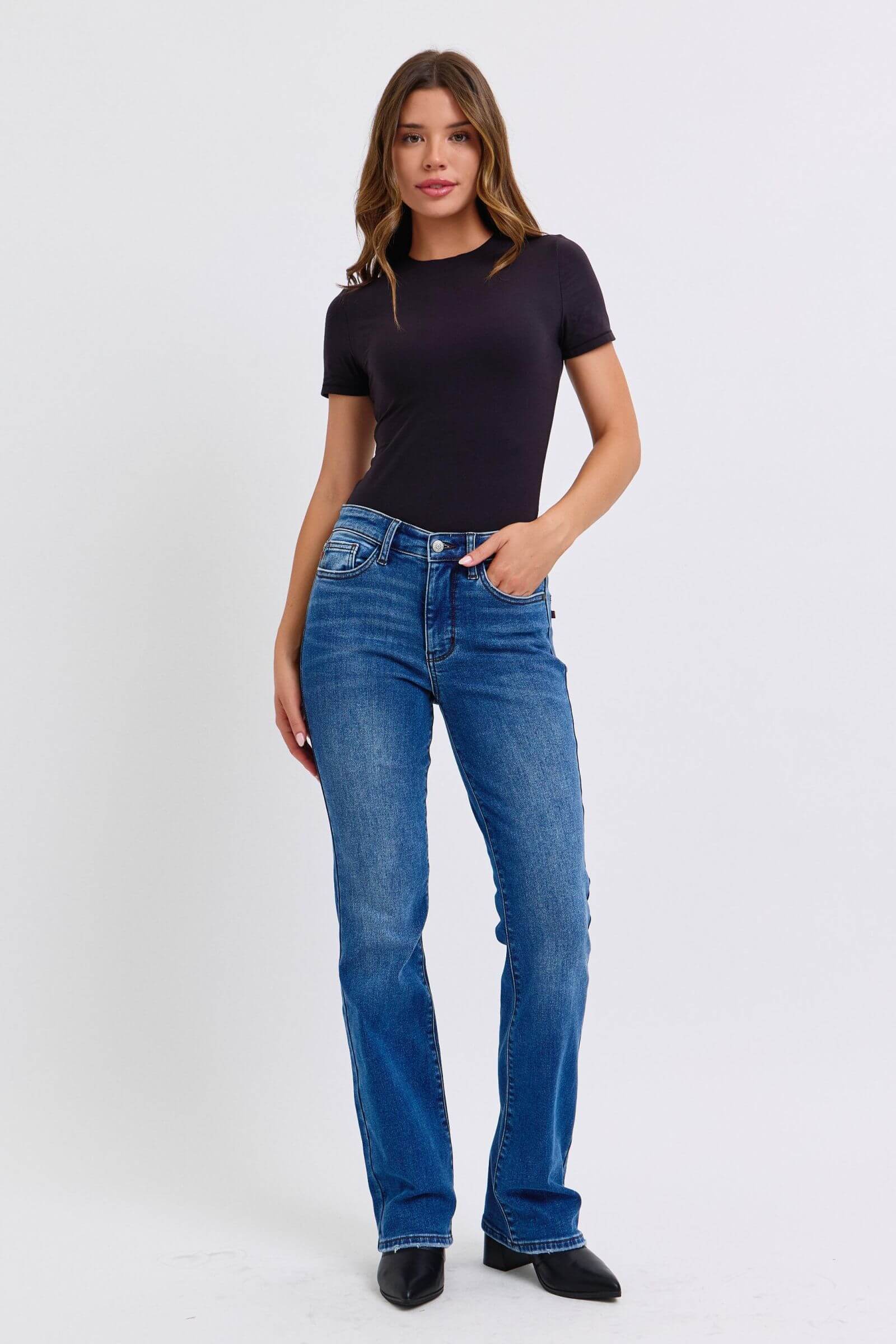 Stylish model in mid-rise bootcut jeans with thermal lining, paired with a sleek black top. Perfect for any occasion!