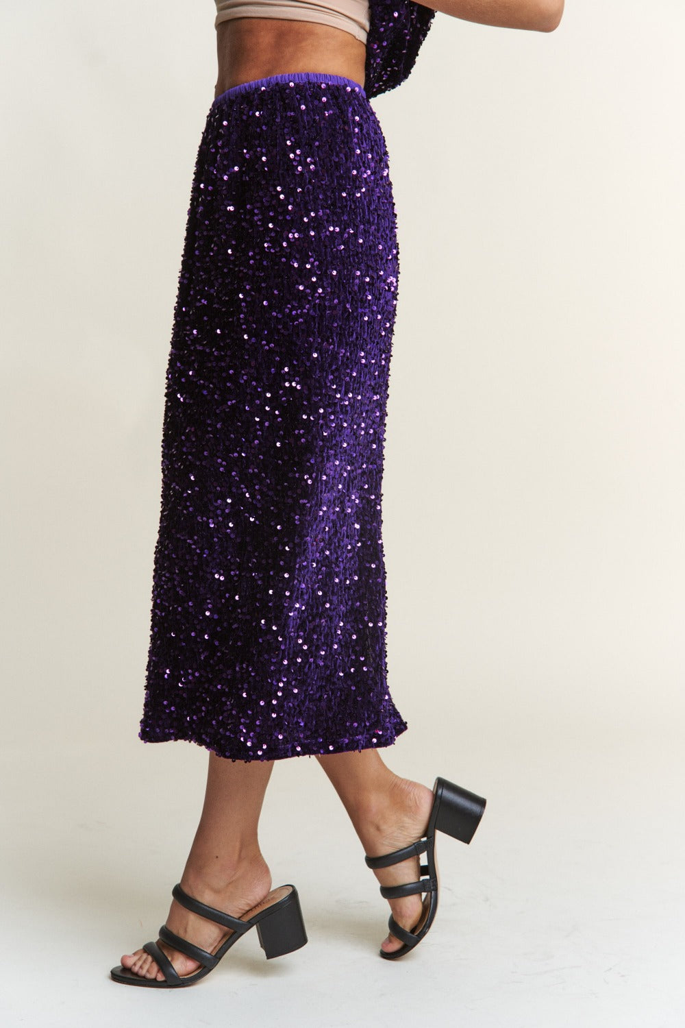 Elegant purple sequin midi skirt with back slit, perfect for glamorous nights out and special occasions.