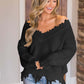 Woman wearing Bella Road frayed hem dropped shoulder sweater, black knit, casual chic look.