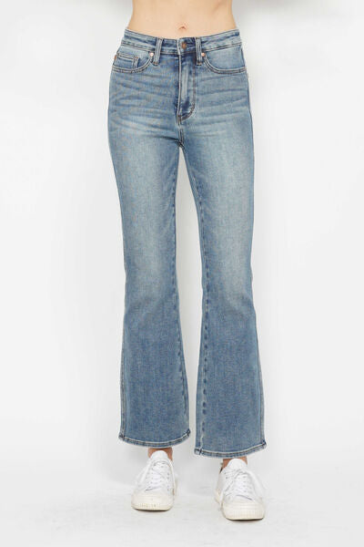 Plus size bootcut jeans with tummy control and embroidered back pockets, styled for a trendy look.