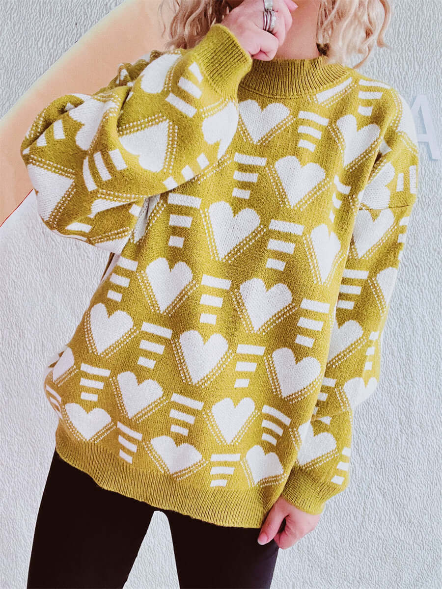 Woman wearing Bella Road Heart Contrast Long Sleeve Dropped Shoulder Sweater in green with white heart pattern, cozy and stylish.