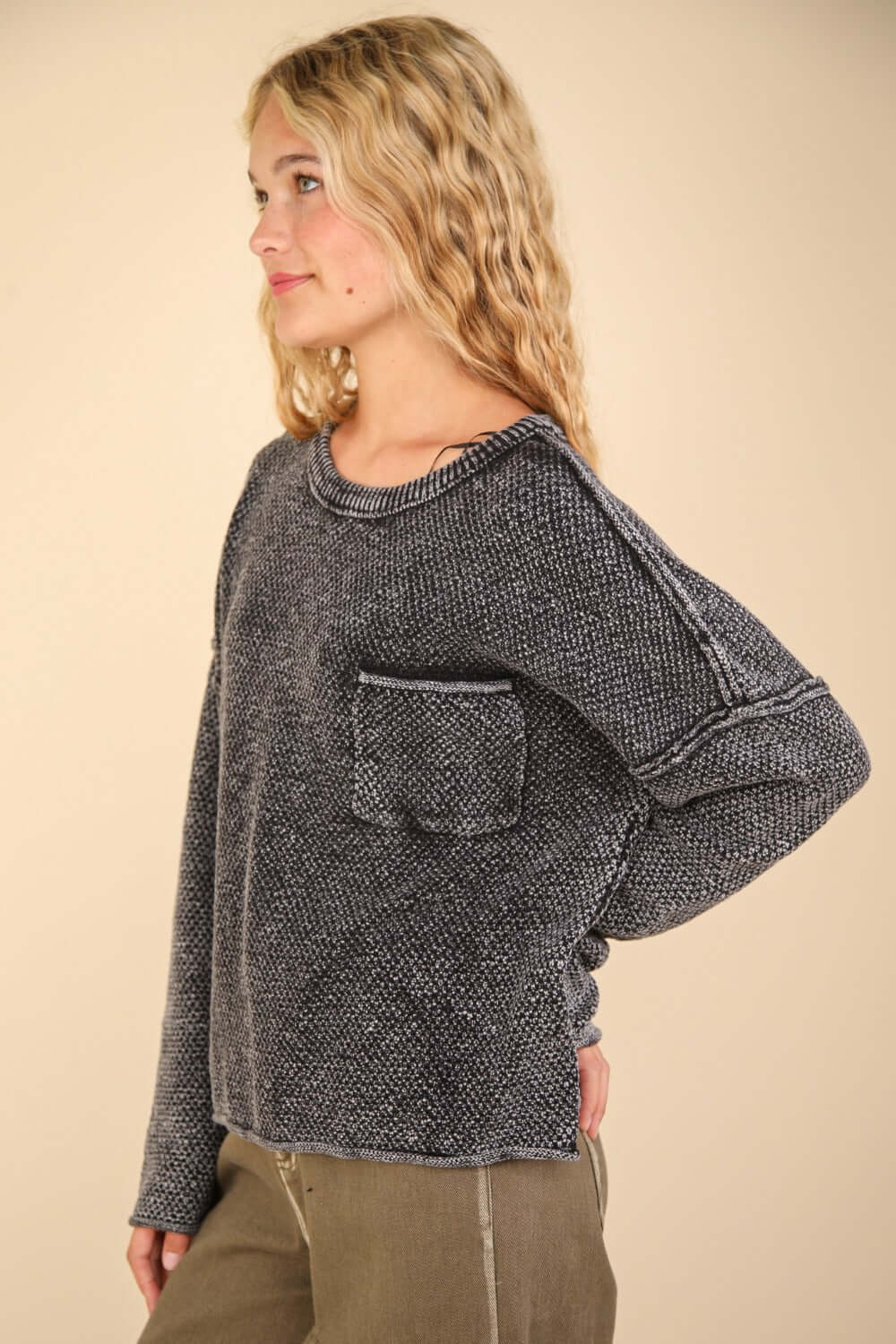 Woman wearing a VERY J Mineral Washed Exposed Seam Sweater with drop shoulder and patch pocket, showcasing its relaxed fit and vintage fabric.