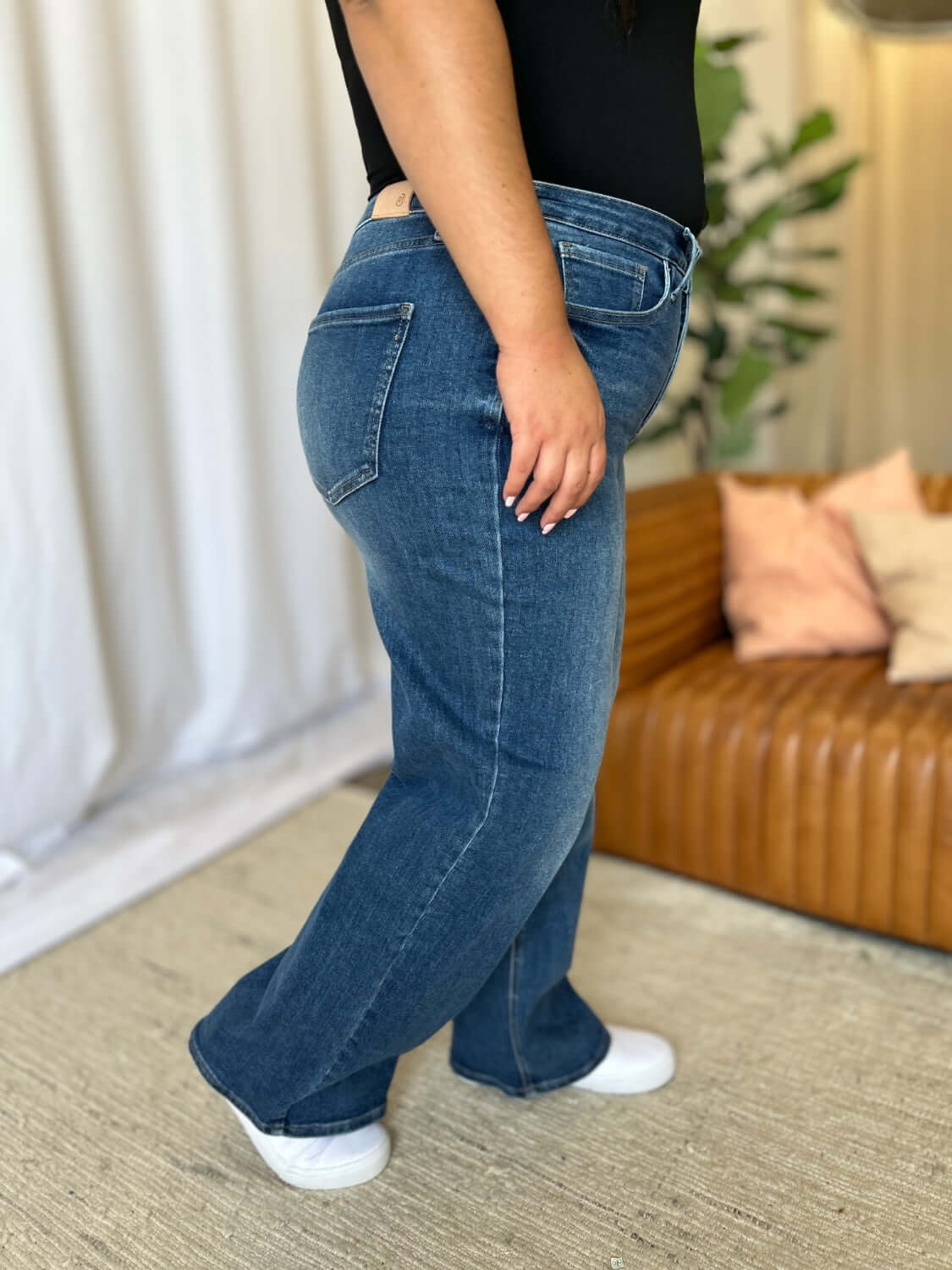 Woman wearing RFM full size high rise tummy control wide leg jeans showcasing a relaxed and stylish silhouette