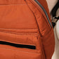 Close-up of an orange nylon backpack showcasing its durable material and stylish zipper detail. Perfect for travel!