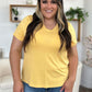 Woman wearing Bamboo V-Neck High-Low T-Shirt in yellow, showcasing a casual and comfortable fit.