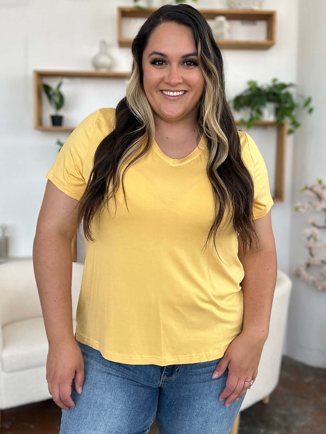 Woman wearing Bamboo V-Neck High-Low T-Shirt in yellow, showcasing a casual and comfortable fit.