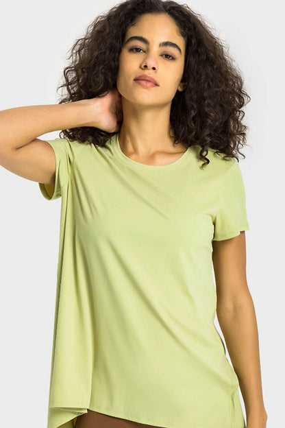 Model showcasing the Millennia Tie Back Short Sleeve Sports Tee in light green, perfect for stylish workouts and everyday wear.