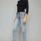 Woman wearing high waist button fly raw hem cropped straight jeans with a black top and beige heels