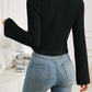 Woman wearing Bella Road black ribbed drawstring long sleeve t-shirt with blue jeans.