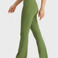 Model showcasing Millennia Elastic Waist Flare Yoga Pants in green, designed for comfort and flexibility in workouts.