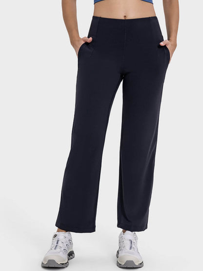 Woman wearing Millennia Pocketed High Waist Active Pants, showcasing pockets and a comfortable fit for workouts.