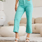 Woman wearing Crop Chloe Full Size Tummy Control High Waist Raw Hem RFM Jeans in aqua paired with white top and sandals