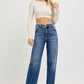 Model showcasing RISEN Full Size Tummy Control High Rise Jeans with a cropped top and stylish white heels.