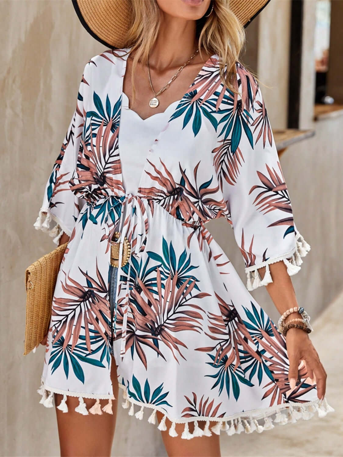 Model in Bella Road Swim Tassel Tied Printed Half Sleeve Cover Up with floral design and tassel trim, ideal for beachwear.