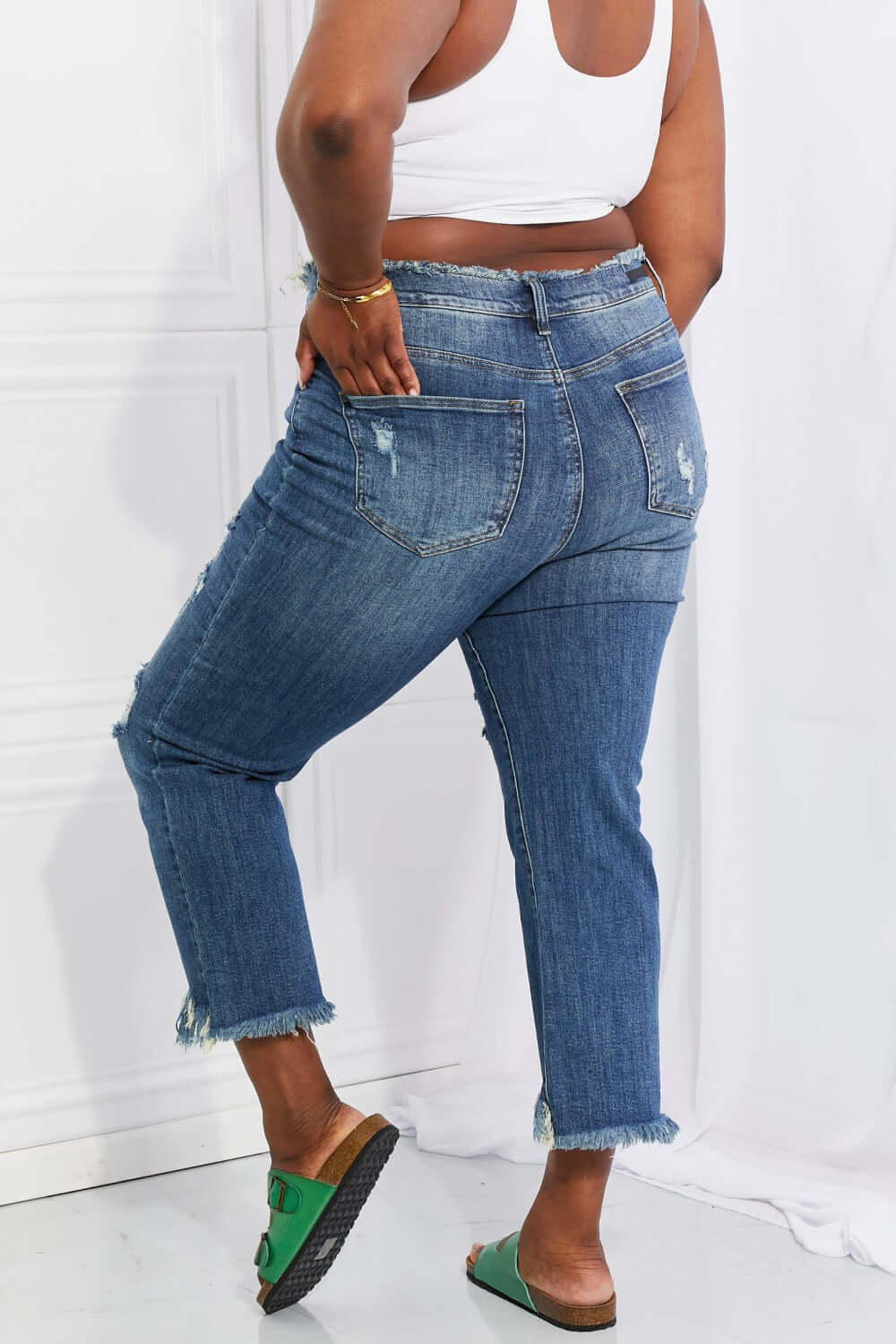 Back view of person wearing Risen Jeans Undone Chic Straight Leg Jeans, showcasing distressed details, raw hem, and cropped length.