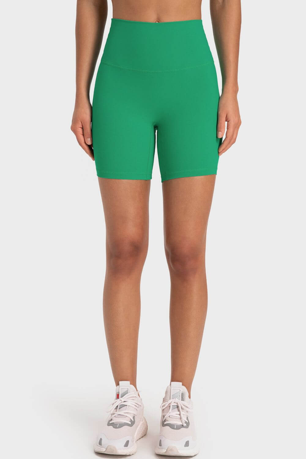 Green wide waistband biker shorts for women, ideal for workouts with slightly stretchy nylon and spandex fabric.