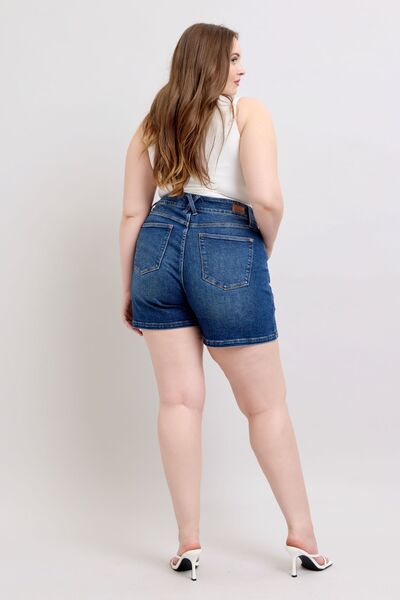 Back view of a plus size model wearing Judy Blue double button denim shorts, showcasing high-waisted style and comfort.