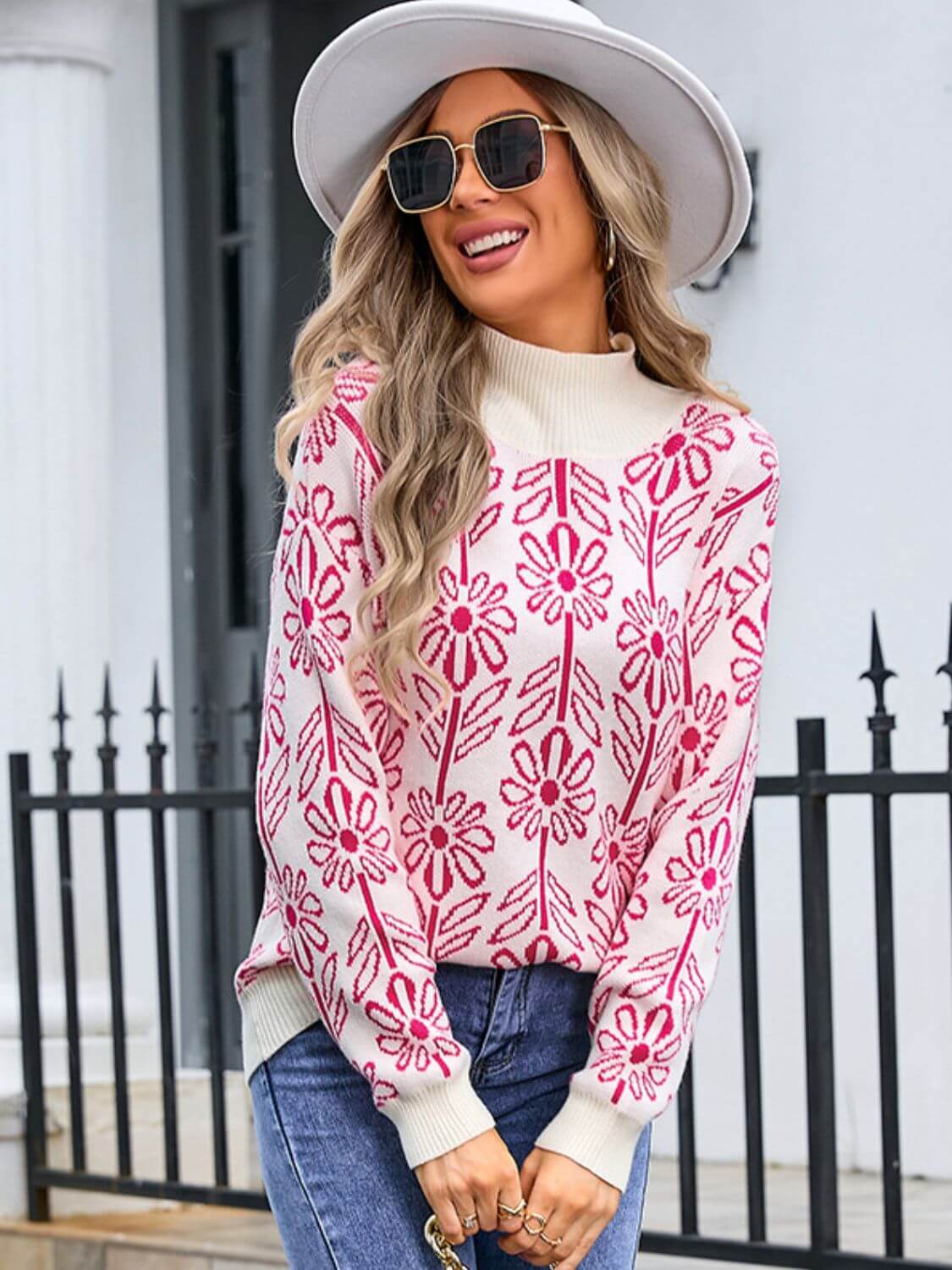 Stylish woman in Angel Wings Flower Turtleneck Sweater, smiling outdoors in a chic hat and sunglasses.