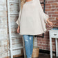 Woman wearing Bella Road Round Neck Batwing Sleeve Sweater in cozy, stylish design with casual jeans, standing indoors.