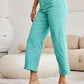 Woman wearing Crop Chloe Full Size Tummy Control High Waist Raw Hem Jeans in turquoise from RFM Jeans.