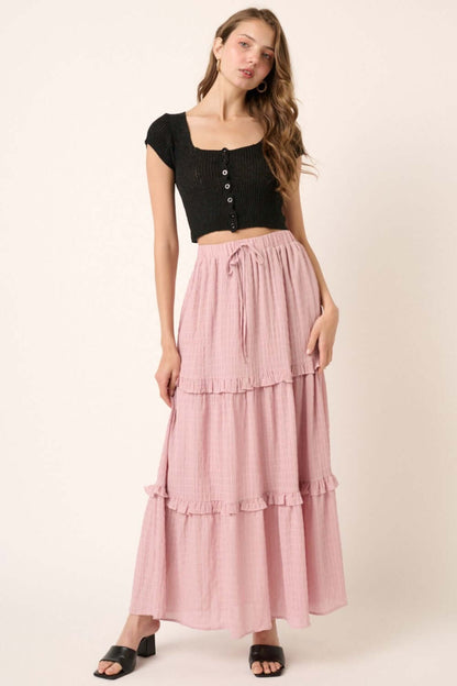 Woman wearing a Drawstring High Waist Frill Skirt in pink paired with a black top, showcasing the skirt's adjustable drawstring and elegant frill details.