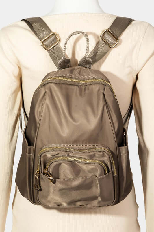 Versatile multi pocket nylon backpack bag in a stylish taupe color, perfect for daily use and travel adventures.