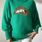 Woman wearing Bella Road Lip Turtleneck Long Sleeve Sweater in green with bold lip design, showcasing unique fashion style.