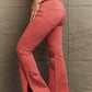 Woman wearing Bailey High Waist Side Slit Flare Jeans in coral, showing side slit details and flattering high-rise fit. Risen Jeans.