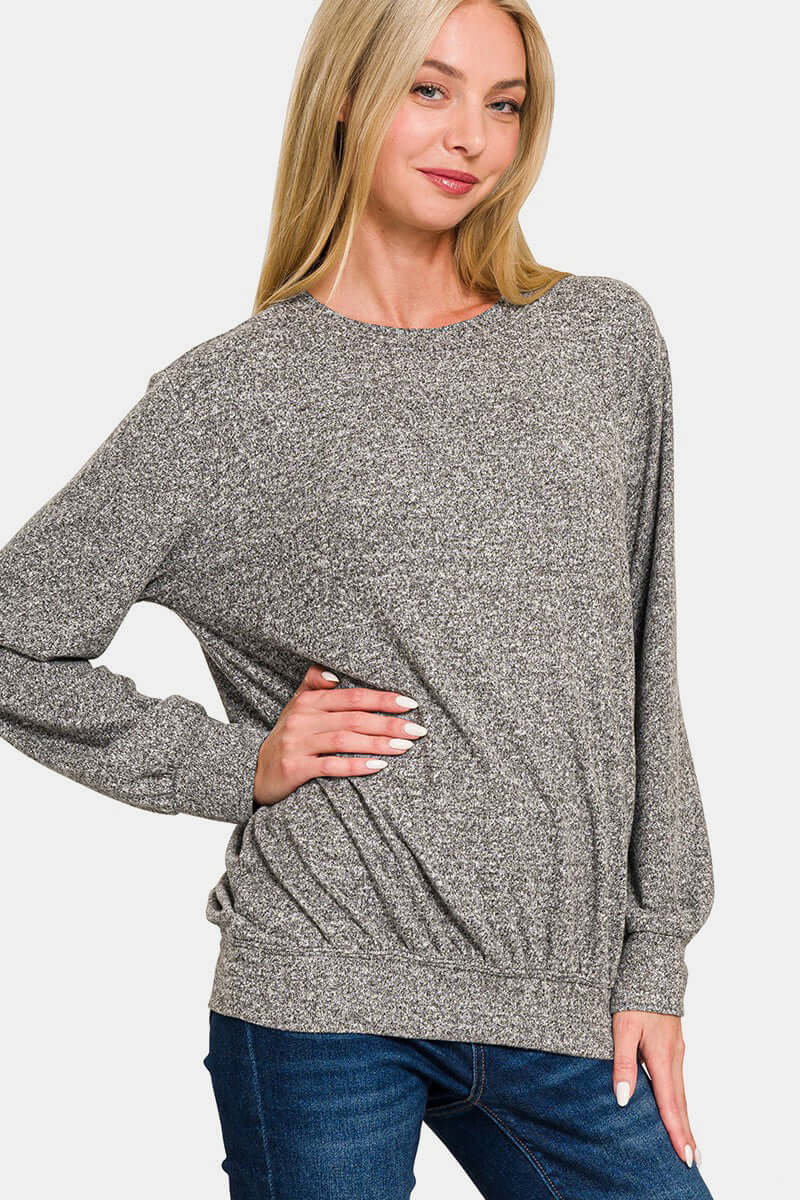 Woman wearing Zenana Full Size Melange Round Neck Top, showcasing its soft texture and stylish versatile design for any outfit.