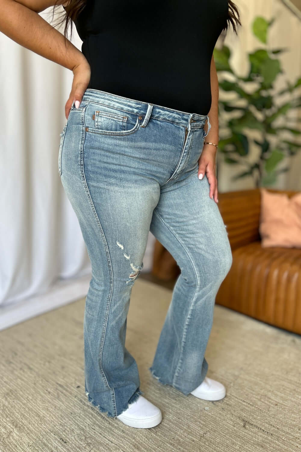 Medium rise tummy control destroy flare jeans with distressed details, highlighting comfort and modern style for a flattering fit.