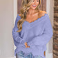 Woman wearing Bella Road frayed hem dropped shoulder sweater in purple, adding quirky fun to her casual outfit.