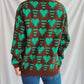 Woman wearing Bella Road Heart Contrast Long Sleeve Dropped Shoulder Sweater in green and brown with heart pattern