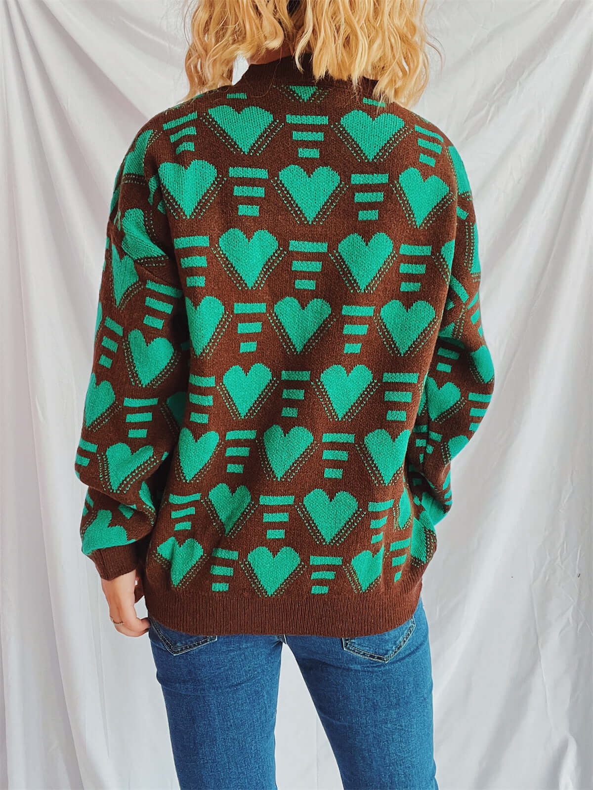 Woman wearing Bella Road Heart Contrast Long Sleeve Dropped Shoulder Sweater in green and brown with heart pattern