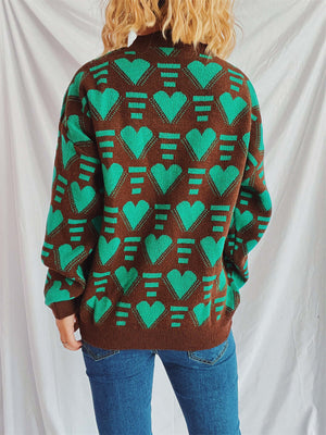 Woman wearing Bella Road Heart Contrast Long Sleeve Dropped Shoulder Sweater in green and brown with heart pattern