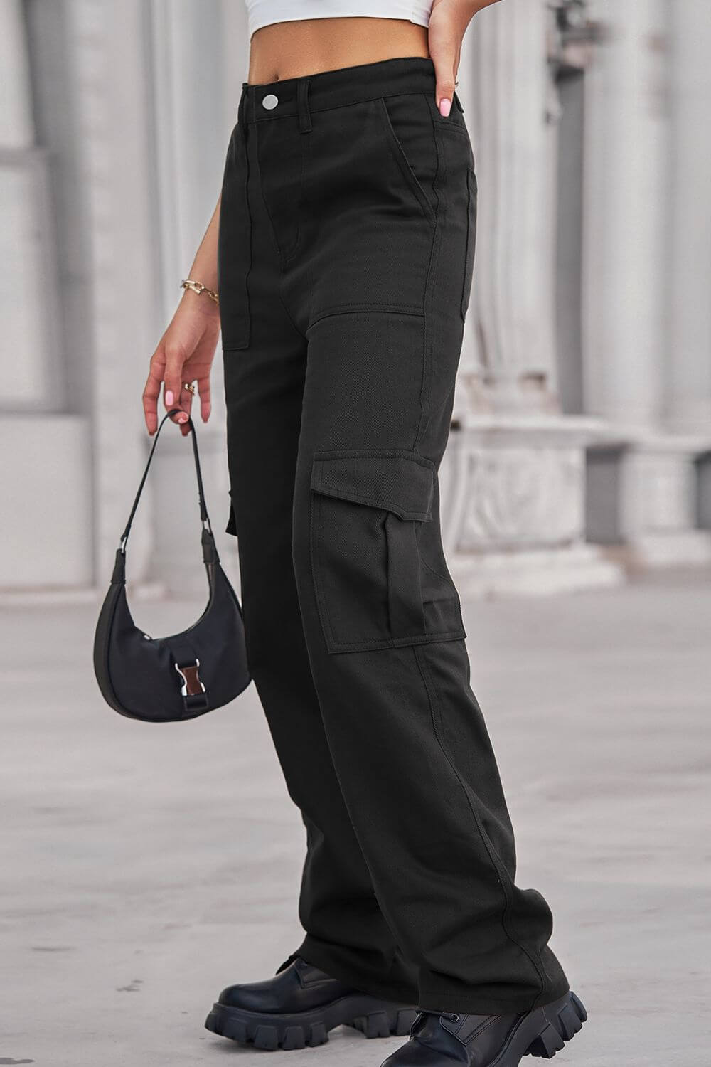 Woman wearing Baeful Long Straight Leg Jeans with Pockets in black, paired with a small handbag and chunky shoes.