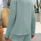 Woman wearing Double Take round neck long sleeve top and shorts set in light green, back view.